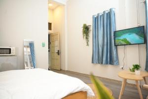 a room with a bed and a tv on a wall at Four Seasons Serenity Studio - SDhousing branch in Hanoi +8 photos