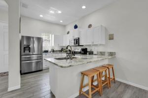 a kitchen with white cabinets and a counter with stools at Much Needed Private Relaxation Home in Davenport