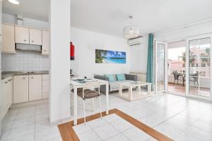 a kitchen and living room with a couch and a table at Apto 5 Almoraide Suites in Nerja