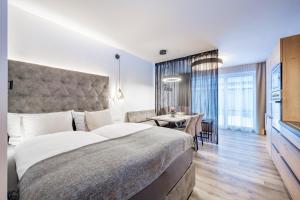 a bedroom with a large bed and a dining room at MYALPS Jordans Lodge in Längenfeld