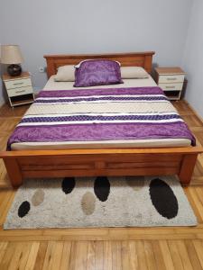 een bed in een kamer met twee nachtkastjes en een kleed bij Signorina in Sajmište