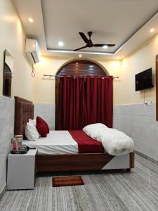 een slaapkamer met een bed met een rood gordijn bij Shree Gopal Inn in Varanasi