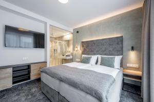 a bedroom with a large bed and a flat screen tv at MYALPS Jordans Lodge in Längenfeld