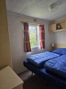 ein Schlafzimmer mit einem blauen Bett und einem Fenster in der Unterkunft Beach Resort Kamperland - 1113 in Wissenkerke