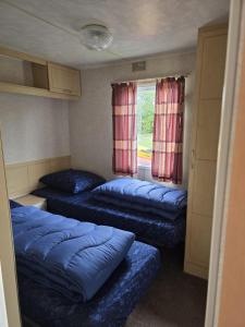 ein kleines Zimmer mit zwei Betten und einem Fenster in der Unterkunft Beach Resort Kamperland - 1113 in Wissenkerke + 2 Fotos