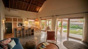 Una sala de estar con cocina y comedor. en Irama Surf Villas, en Sekongkang Bawa