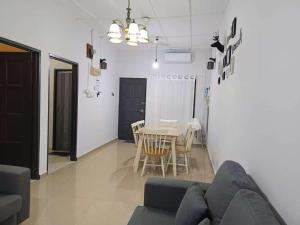 een woonkamer met een bank en een tafel bij Melaka Kota Home in Melaka