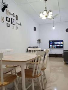 een eetkamer met een witte tafel en stoelen bij Melaka Kota Home in Melaka +7 foto's