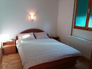 um pequeno quarto com uma cama e uma janela em Apartments Vojinovic em Žabljak
