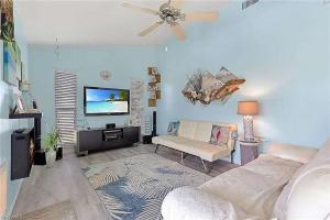 a living room with a couch and a flat screen tv at Summer Getaway (Gulf-access retreat) in Cape Coral