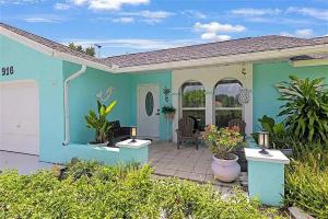 a blue house with a patio in front of it at Summer Getaway (Gulf-access retreat) in Cape Coral