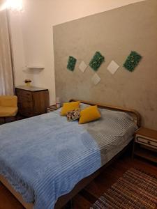 um quarto com uma cama com lençóis azuis e almofadas amarelas em Camera Privata Vicino al Teatro Ariston em Sanremo