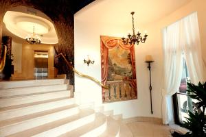 a staircase with a chandelier and a painting on the wall at Zeus Essence Bucharest Opera in Bucharest
