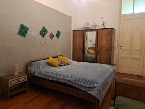 um quarto com uma cama com almofadas amarelas e um armário em Camera Privata Vicino al Teatro Ariston em Sanremo