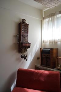 a room with a couch and a clock on the wall at Arariwa in Cochabamba