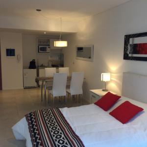 1 dormitorio con 1 cama blanca, mesa y sillas en Casa ivana 3 en Buenos Aires
