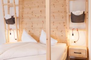 a bedroom with a white bed with a wooden wall at Hotel-Chalet Pennhof in Barbiano +83 photos