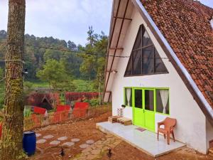 a green door on the side of a white house at Aubrey Villa Ciwidey in Pengalengan