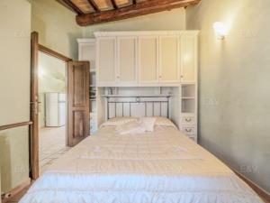 ein Schlafzimmer mit einem großen Bett und weißen Schränken in der Unterkunft la casa nel borgo in Bevagna