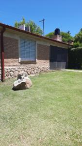 ein Haus mit einem Felsen vor einem Hof in der Unterkunft Casa en Nono in Nono