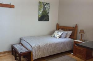 een kleine slaapkamer met een bed en een foto aan de muur bij 'The Cape Robin' studio apartment in Hoheizen