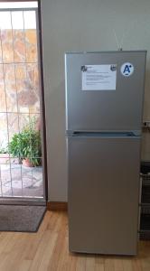 a refrigerator in a room next to a door at 'The Cape Robin' studio apartment in Hoheizen