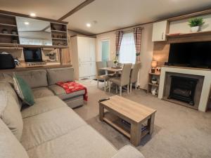 a living room with a couch and a fireplace at Foxwood Hideaway in Carnforth