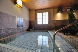 a swimming pool in a building with a tile floor at Dormy Inn Express Koriyama in Koriyama