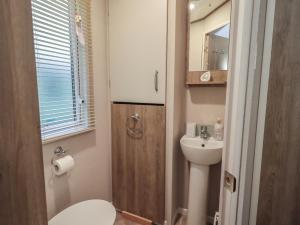 a small bathroom with a toilet and a sink at Foxwood Hideaway in Carnforth +13 photos