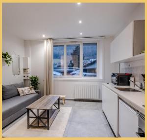a kitchen and living room with a couch and a table at L'Ecrin du Lac I Studio I Sévrier in Sévrier