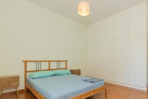 a bedroom with a bed and white walls at Mulberry House by the Sea Νέα Μάκρη in Nea Makri