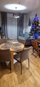 a living room with a table and a christmas tree at Apartament Słoneczna Dolina SPA Belle View in Szklarska Poręba