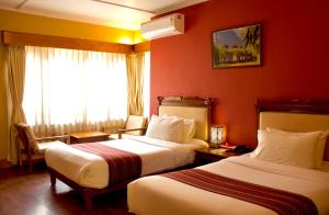 Dragon Nest Resort في Wangdiphodrang: غرفة فندق بها سريران ونافذة