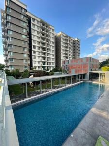 een zwembad voor een aantal hoge gebouwen bij Jhomestay1 in Sandakan