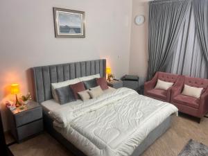 a bedroom with a large bed and a red couch at Mohib Home Stay in Lahore