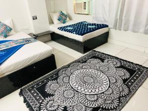 two beds in a room with a rug on the floor at Hotel Churu Palace in Jaipur +36 photos