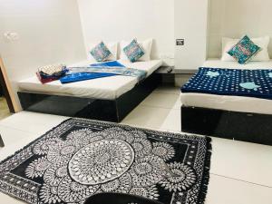 a room with two beds and a rug on the floor at Hotel Churu Palace in Jaipur
