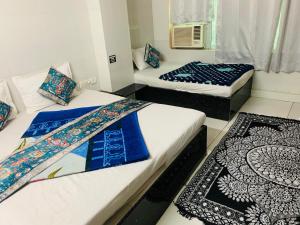 two beds in a room with blue and white at Hotel Churu Palace in Jaipur