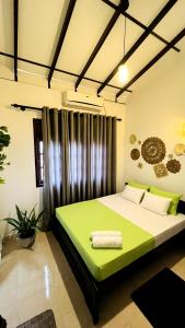 a bedroom with a green bed in a room at Little J villa in Dickwella