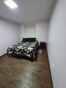a bedroom with a bed in a white room at Cabaña Alfalfares Oriente in La Serena