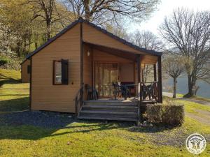 a tiny house with a porch and a deck at Gîte 19G5412 in Soursac