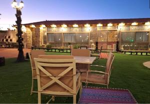 The modern village في ‘Ayn Amūn: فناء مع طاولة وكراسي في العشب