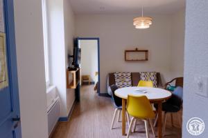 a room with a table and chairs and a couch at Gîte ecole 3 in Soursac