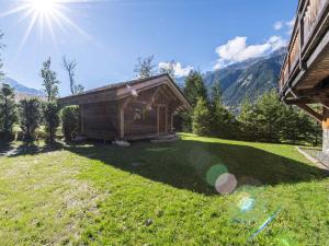 a small cabin in a grassy field with the sun at Luxueux Chalet avec Spa et Vue sur Mont Blanc - FR-1-343-253 in Chamonix-Mont-Blanc