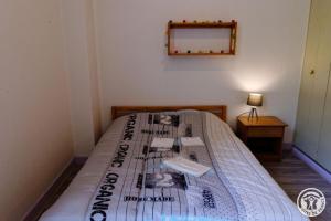 a bedroom with a bed with a newspaper on it at Gite ecole in Soursac