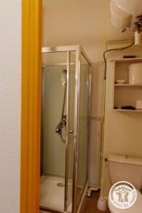 una ducha con puerta de cristal en un baño en Gite ecole, en Soursac