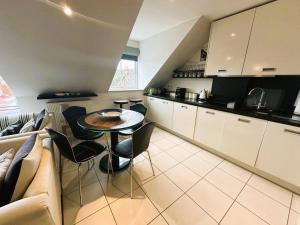 una cucina con un tavolo e sedie in una stanza di Footprints-comfortable and modern one bedroom Apartment - walking distance to the pretty harbour a Saundersfoot