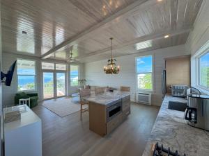 a kitchen with a island in a room with windows at Kalopsia Seaside Villas & Marina in Great Guana Cay
