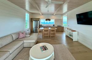 a living room with a couch and a table at Kalopsia Seaside Villas & Marina in Great Guana Cay