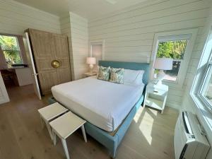 a bedroom with a bed and two windows at Kalopsia Seaside Villas & Marina in Great Guana Cay +58 photos